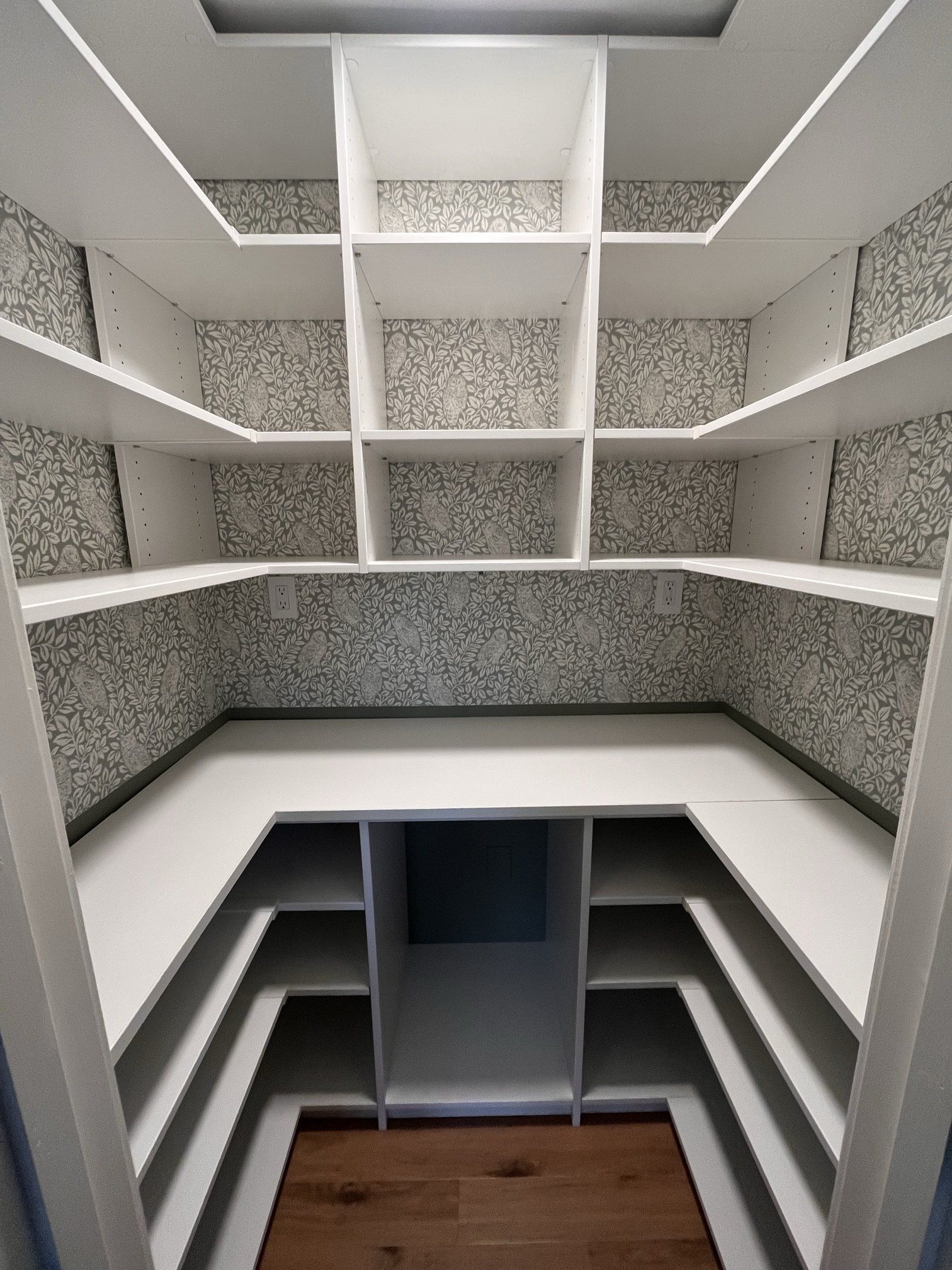 Custom walk-in pantry with white wraparound shelves