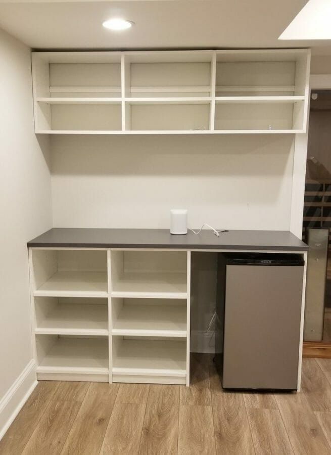 White built-in shelving and counter with a mini fridge