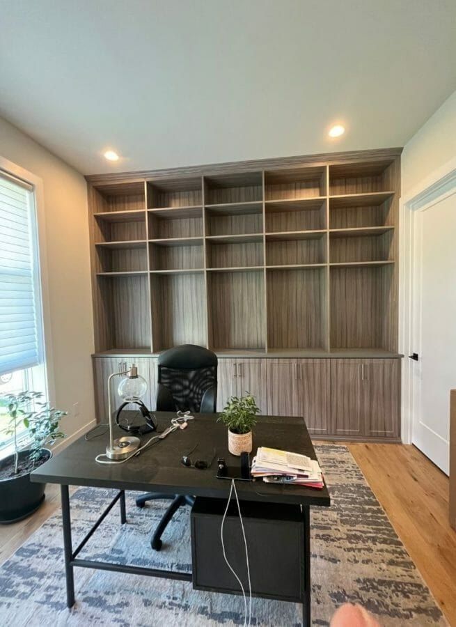Home office with a wood-grain bookcase wall behind the desk