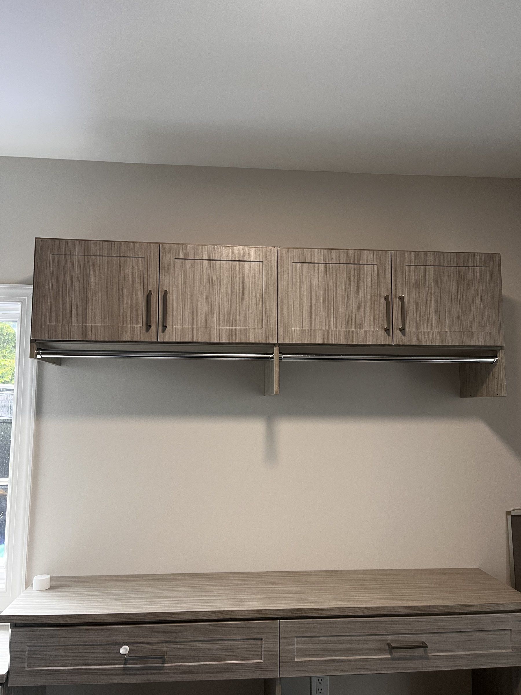 Home office with a built-in desk and floating wood-grain upper cabinets