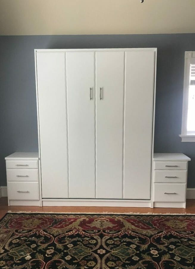 The same white Murphy bed folded up behind cabinet doors