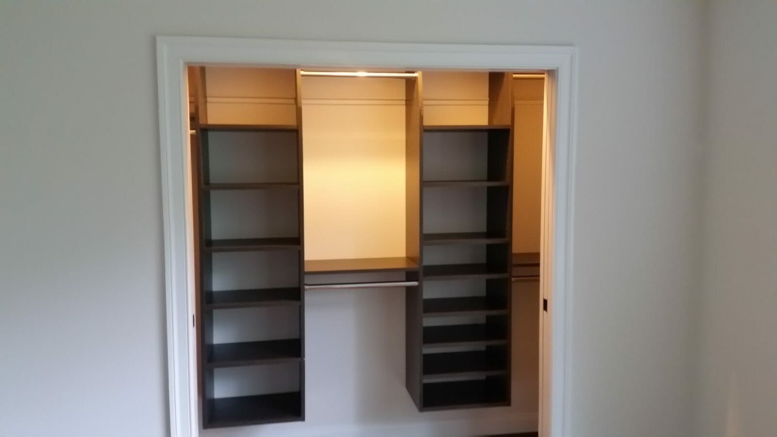 Lit reach-in closet with espresso shelving