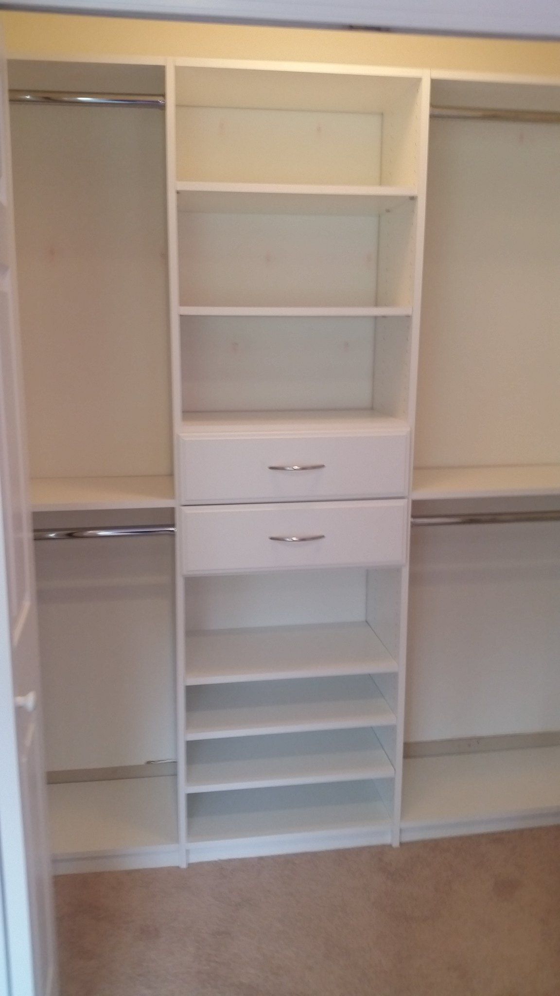 Reach-in closet with angled shoe shelves under a drawer stack