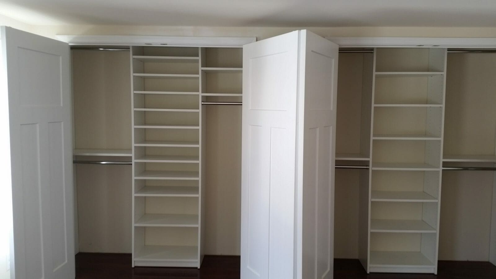 Two white reach-in closets side by side with shelving towers