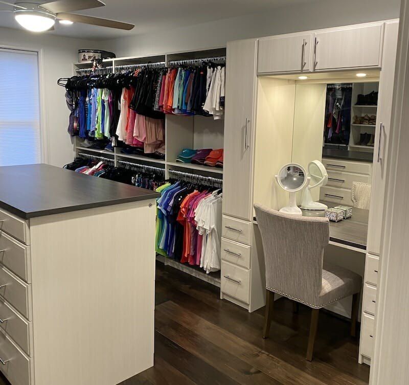 Walk-in closet with a built-in makeup vanity and island
