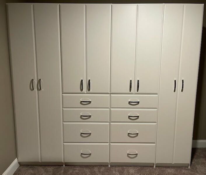 White built-in wardrobe with tall doors and two banks of drawers